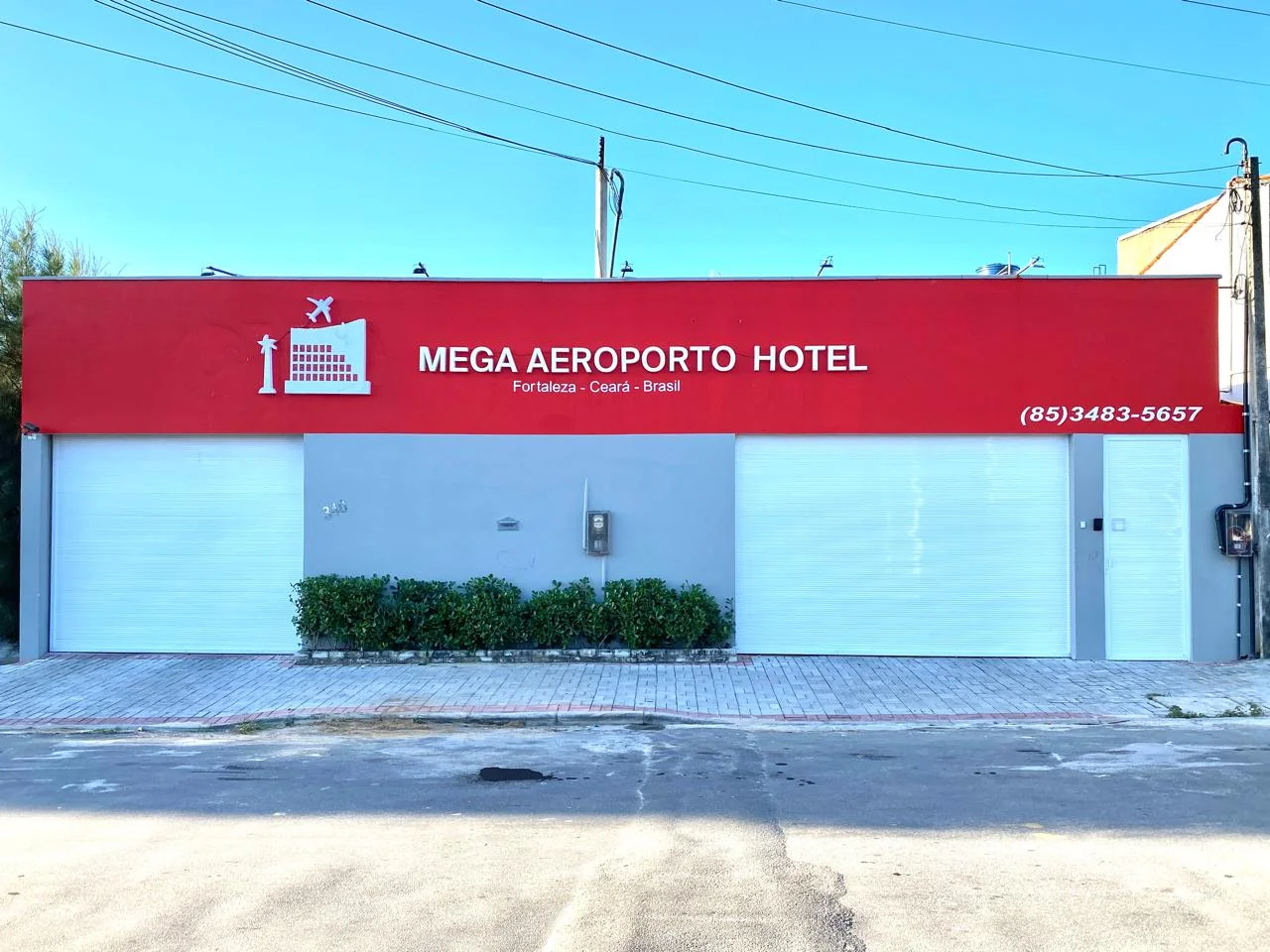 Fachada do Mega Aeroporto Hotel na Rua Leão XIII, com a placa vermelha do hotel